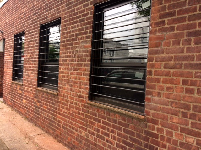 Steel bar window guards installed on a brick building in New York City