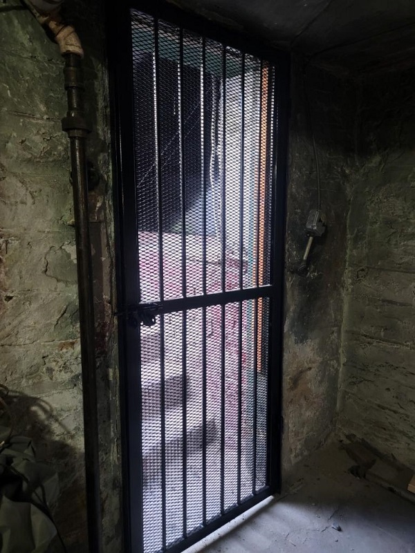 steel security door of expanded metal mesh and half inch solid bars soho new york