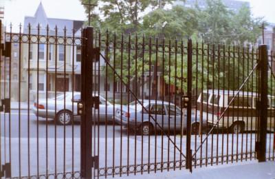 fully welded 8 foot tall solid three quarter square bar fence with cross braces, circles and arrows on top. (close up)