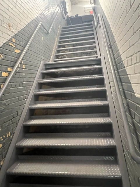 Interior extra long stairs with two landings and wall railings